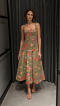 Front view of woman wearing green floral tweed top and midi skirt set