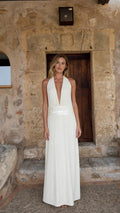Front view of woman wearing white halter neck maxi dress