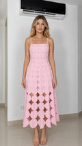 Front view of model wearing pink laser-cut geometric midi dress