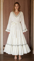 Ivory women's tiered maxi dress with V-neckline, embroidered trim, bell sleeves, and tie waist shown from the front