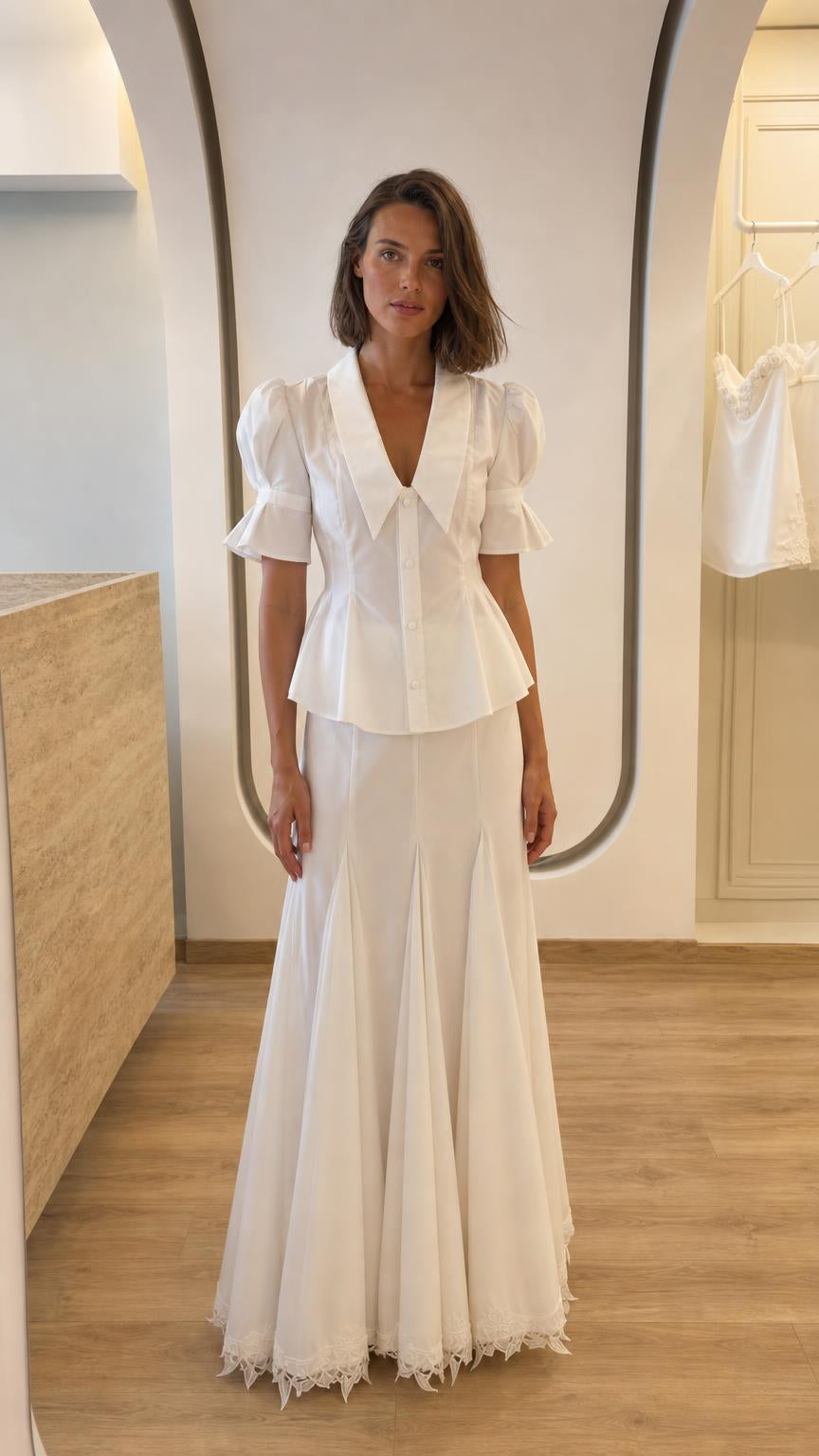 Front view of woman wearing white two-piece peplum top and maxi skirt set