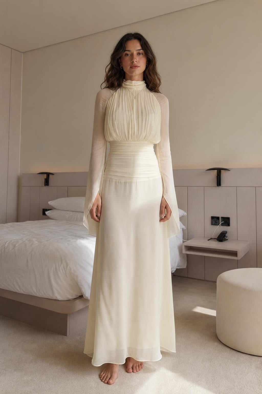 Front view of woman wearing cream pleated high-neck long-sleeve maxi dress