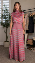 Front view of woman wearing pink high neck printed maxi dress
