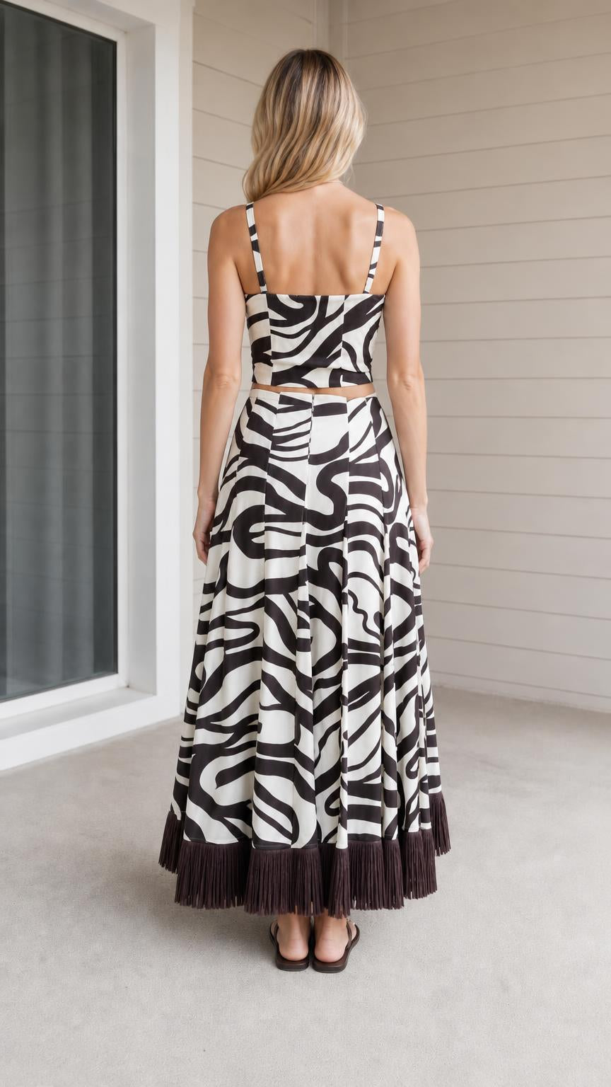 Back view of model wearing zebra print crop top and skirt with fringe hem