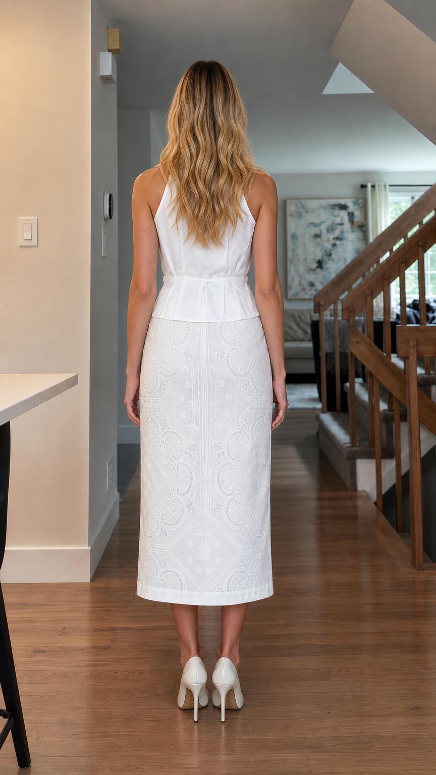 Back view of woman wearing white peplum top and midi skirt