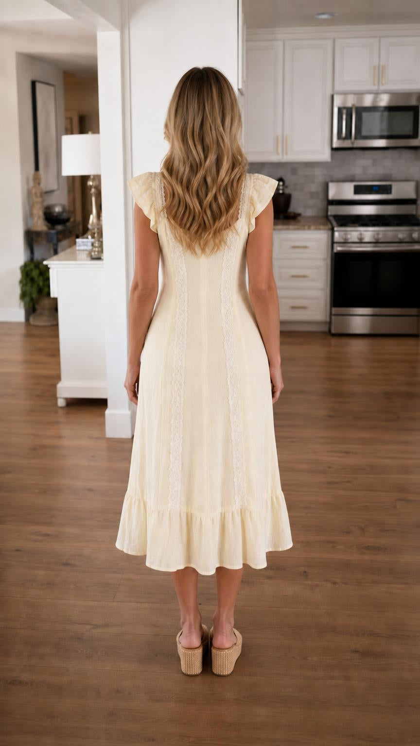 Back view of woman wearing yellow midi dress showcasing tiered hem