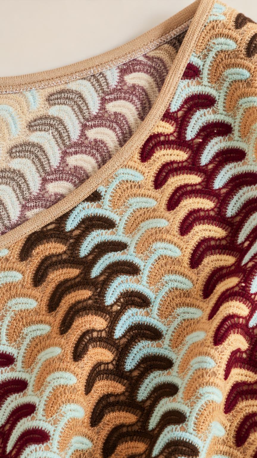 Close-up detail of knit texture and one-shoulder neckline