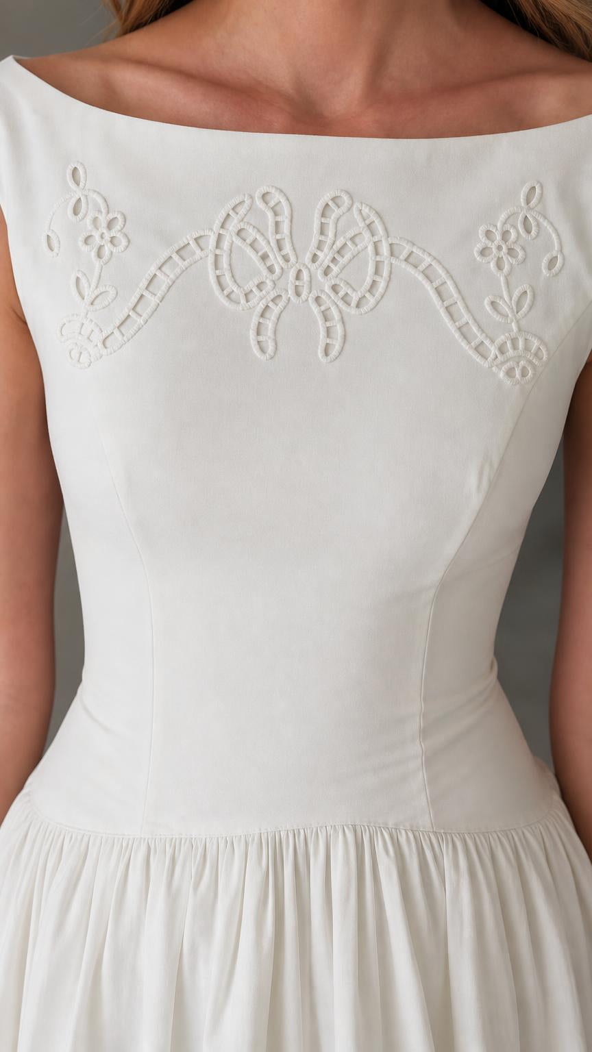 Close-up detail of boatneck and chest embroidery on white dress