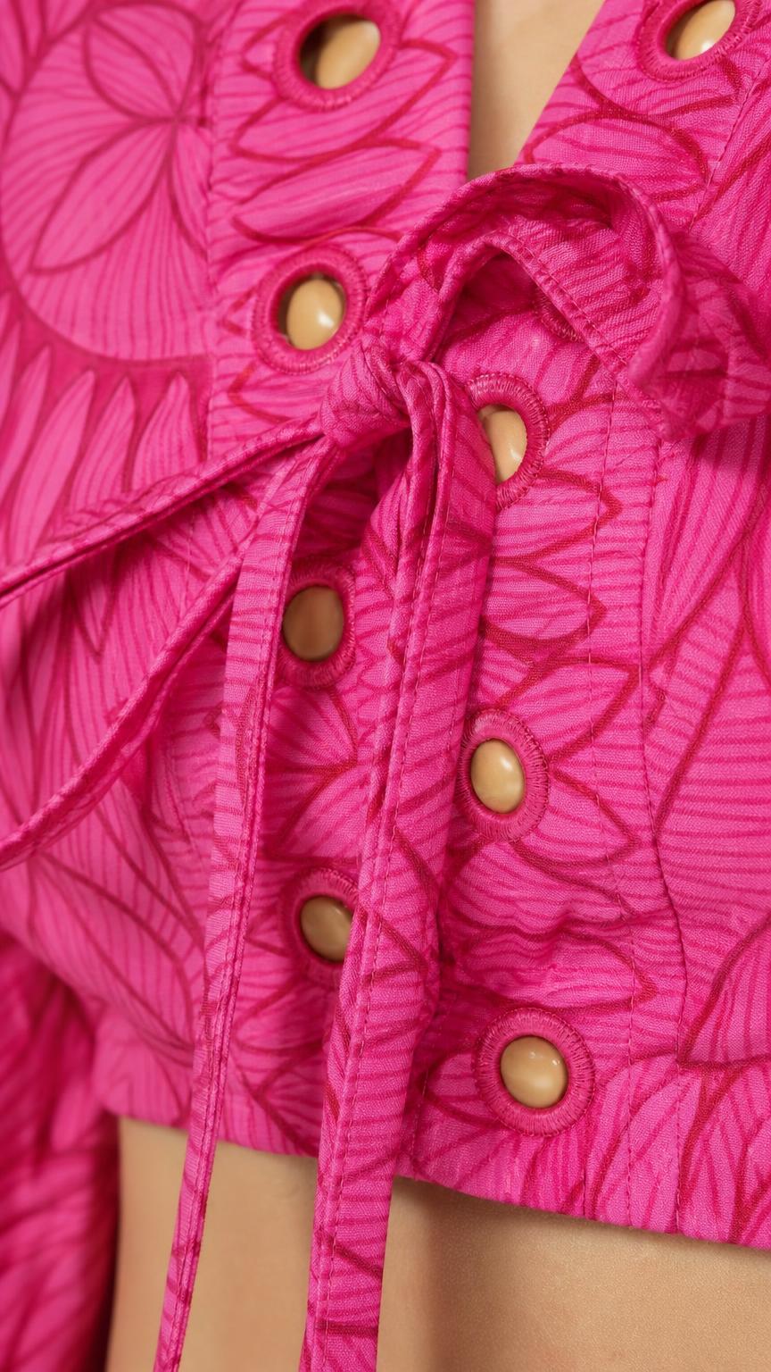 Close-up of front tie and eyelet details on Fuchsia top