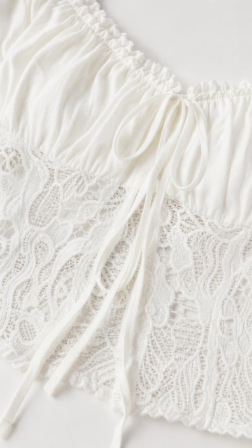 Close-up detail of white crop top lace and drawstring