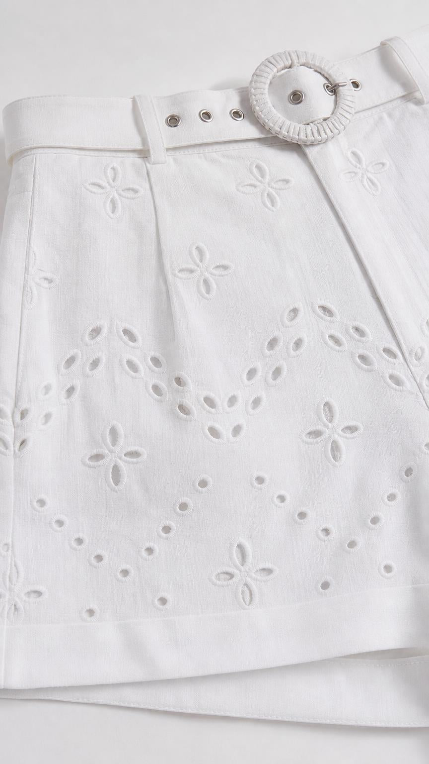 Close-up detail of white eyelet embroidered shorts with belt