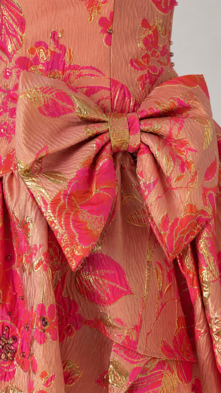 Close-up detail of oversized bow and metallic brocade fabric on dress
