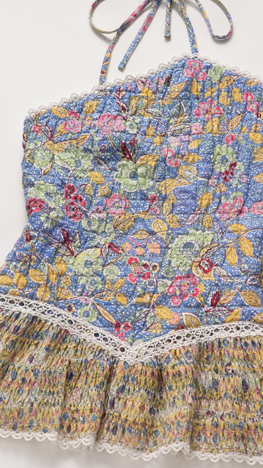 Close-up of blue floral halter mini dress fabric and lace trim detail
