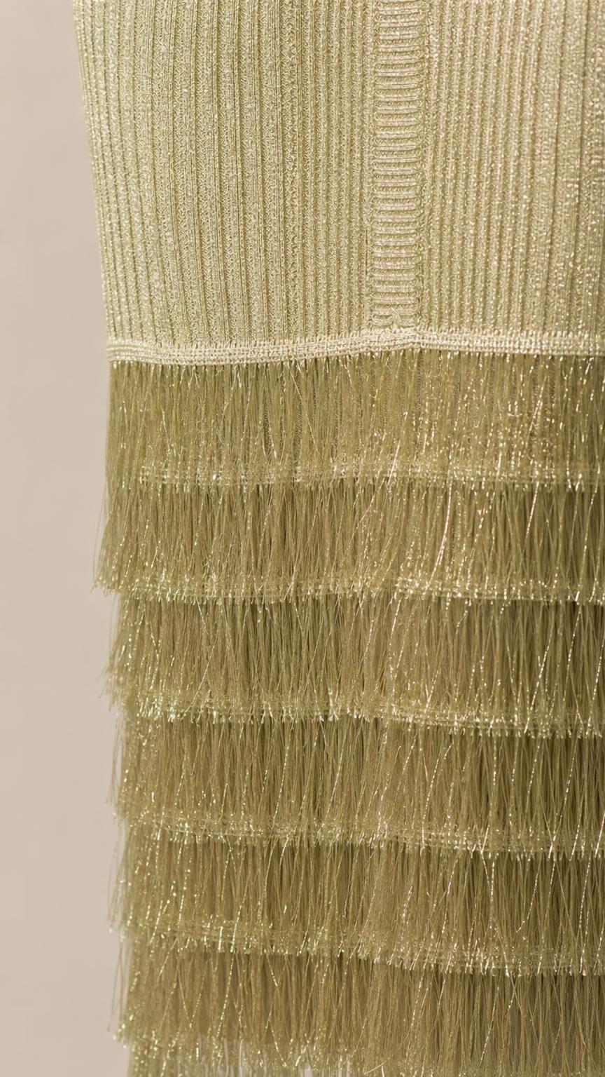Close-up detail of tiered fringe hem on olive midi dress