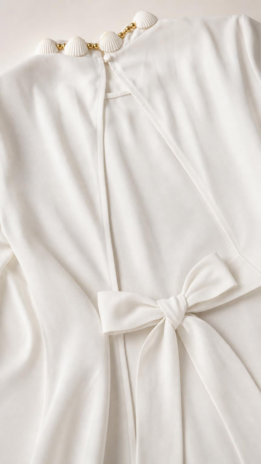 Close-up detail of seashell neckline and back bow