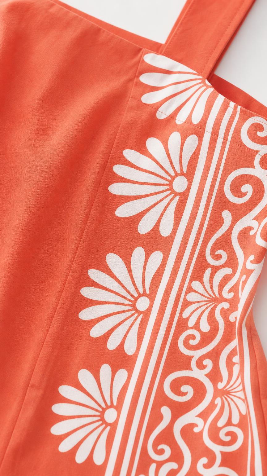 Close up of fabric and botanical print detail on coral dress
