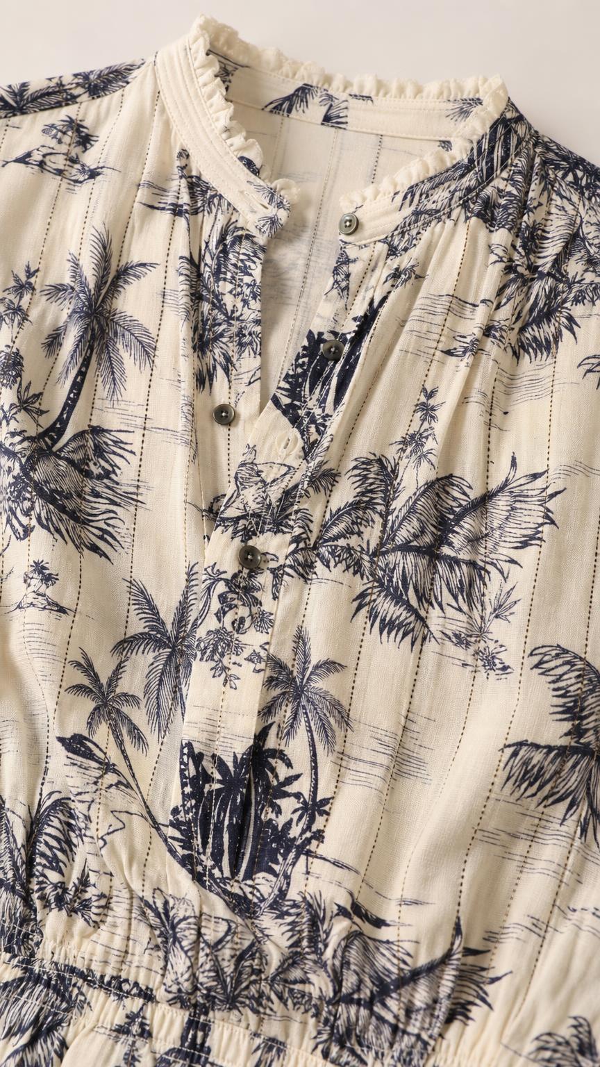 Close-up detail of the ruffled collar, buttons, and fabric texture on ivory romper