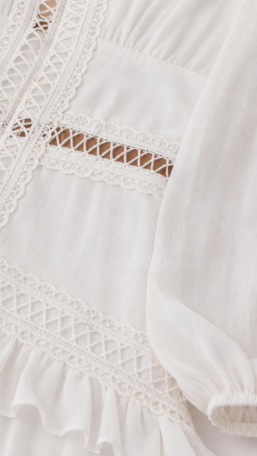 Close-up detail of lace trim and chiffon fabric on White dress