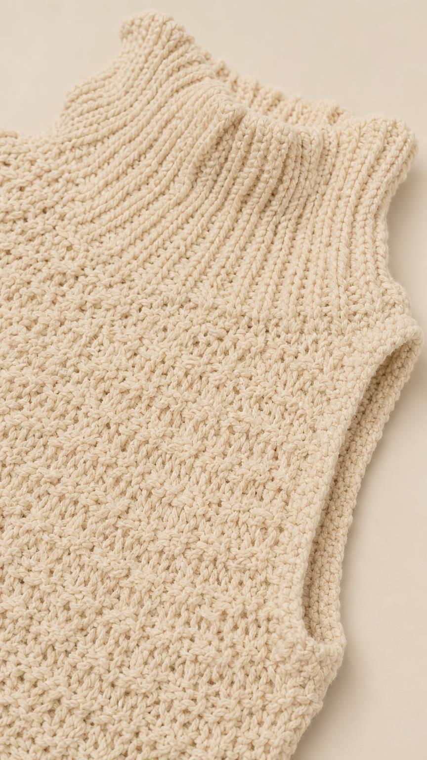 Close-up detail of textured ribbed mock neck and shoulder on cream knit dress