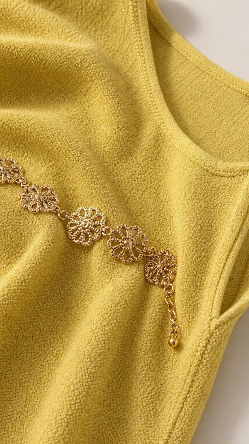 Close-up of textured fabric and gold floral waist chain