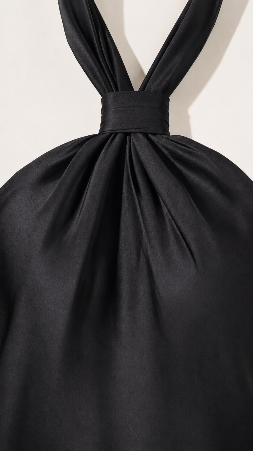 Close-up detail of halter neckline and gathered satin fabric